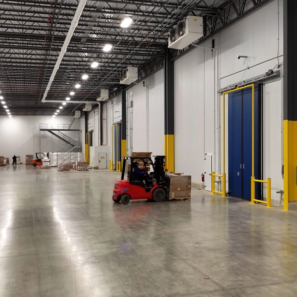 Forklift operator moving pallets near dock bay